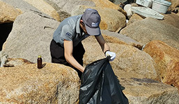 ST employee collecting waste between rocks (photo)