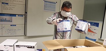 Hands holding masks over an open box